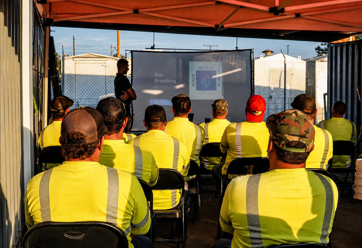 A seated utility crew following a box breathing demonstration during an on-site workshop