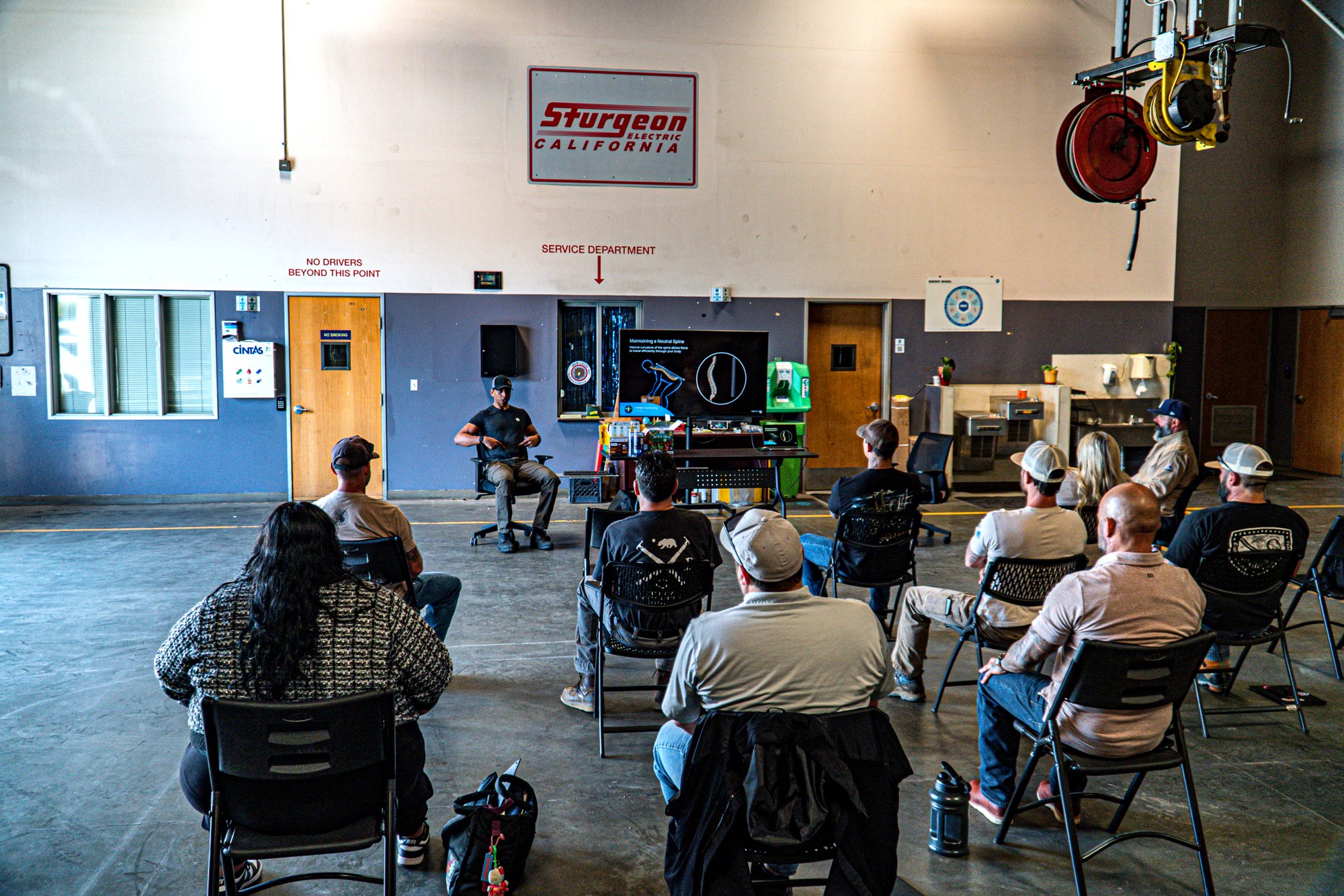 Nicholas Prasad teaching breathing mechanics to a seated industrial crew at Sturgeon Electric