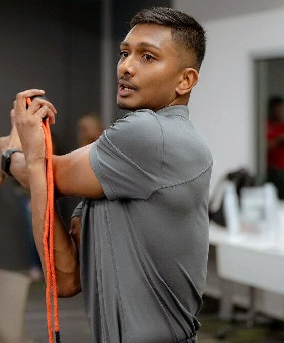 Nicholas Prasad coaching a resistance-band movement during a workshop