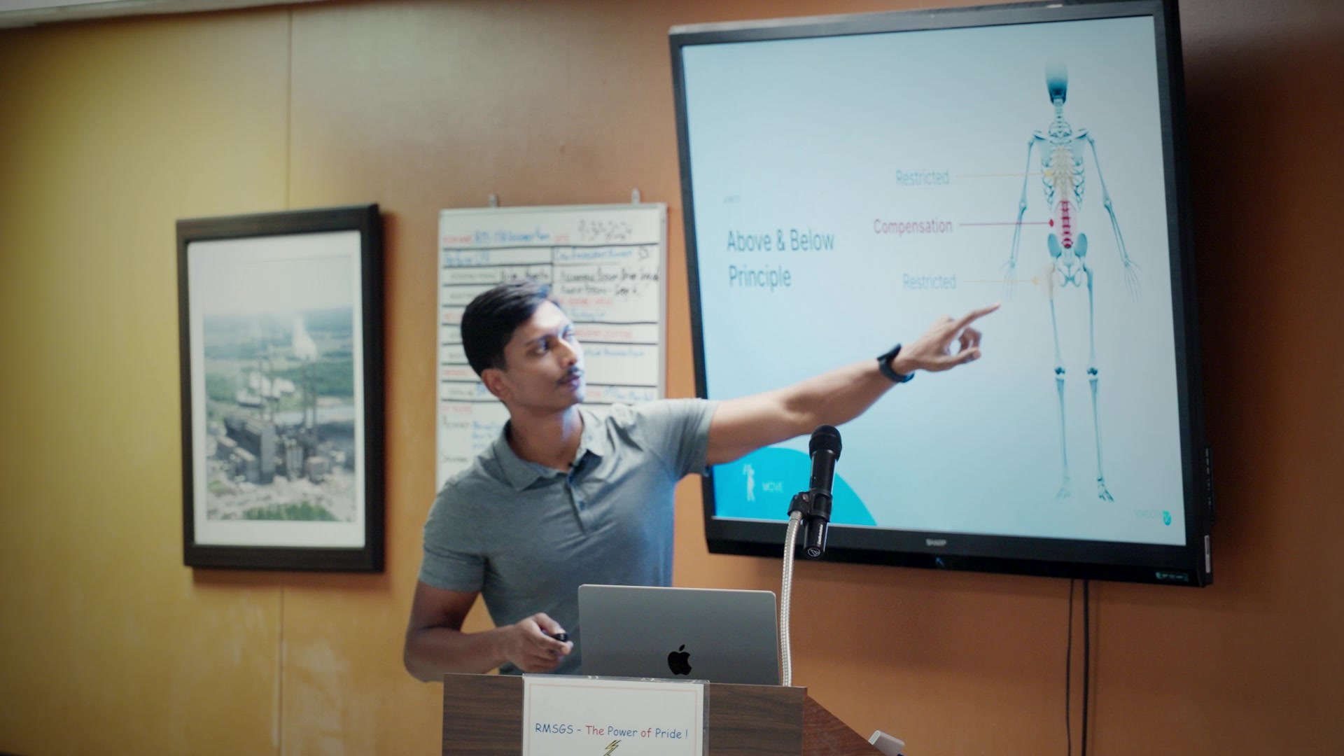 Nicholas Prasad presenting the Above and Below Principle, pointing to an anatomical figure on screen